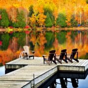 Chairs lakeside amongst vibrant fall foliage